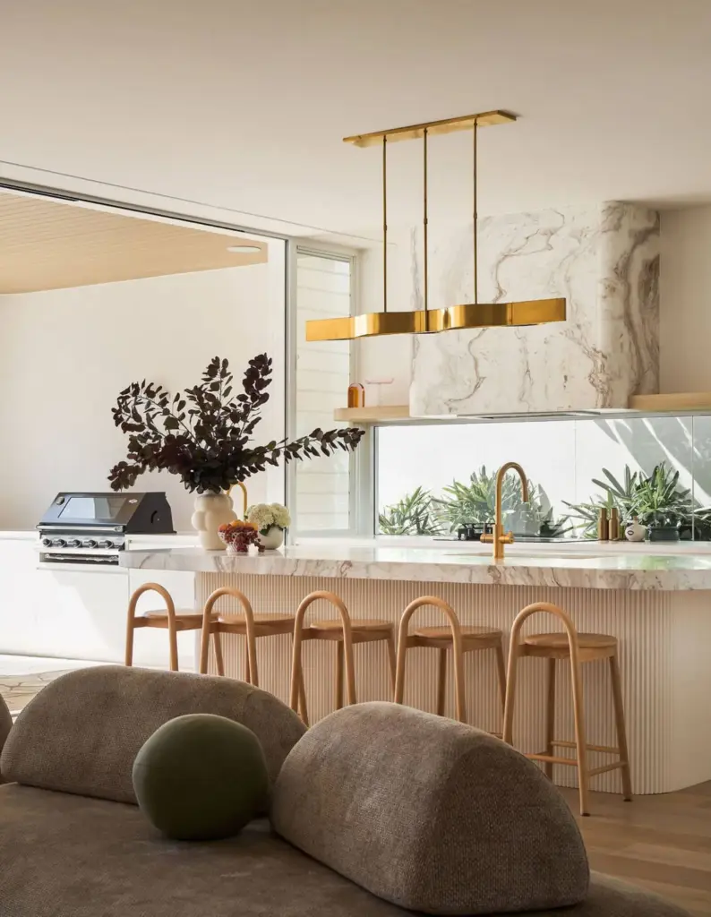 Custom kitchen with marble island and brass pendant, plumbed by Styleside Plumbing